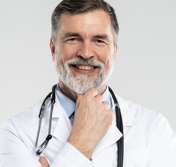 Cheerful mature doctor posing and smiling at camera, healthcare and medicine